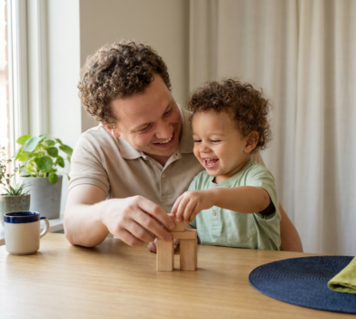 Parent and toddler playing with blocks in a sunny kitchen
